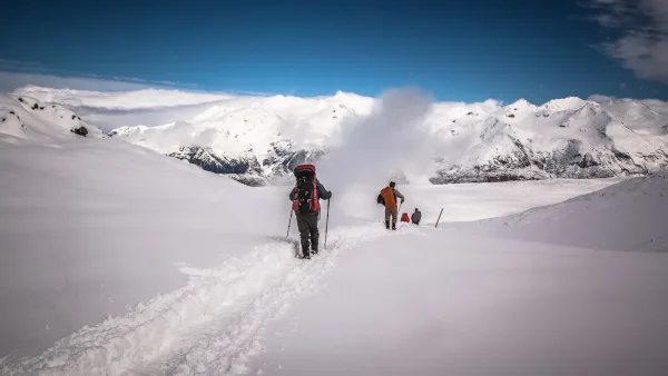 Caminhantes subindo o terreno íngreme e rochoso de Paso Gardner, com um extenso vale glacial visível abaixo.