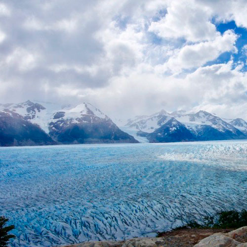 Mochileiros alcançando o cume nevado de Paso John Gardner com vistas para o Campo de Gelo Sul.