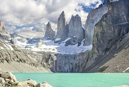 Las agujas verticales de granito de Base de las Torres se alzan imponentes contra el brillante cielo patagónico.
