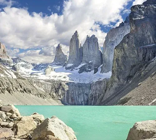 The vertical granite spires of Base de las Torres standing tall against a bright Patagonian sky.