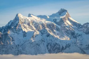 Imponentes cumbres nevadas del Cerro Paine Grande bajo una ligera bruma en la Patagonia chilena.