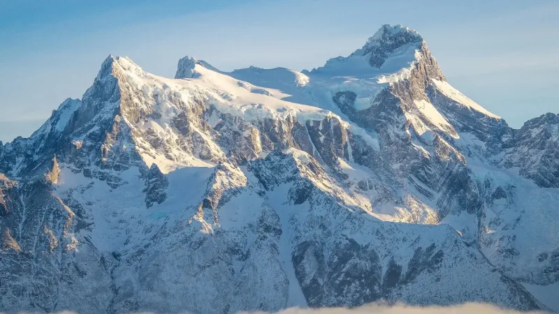 Imponentes cumbres nevadas del Cerro Paine Grande bajo una ligera bruma en la Patagonia chilena.