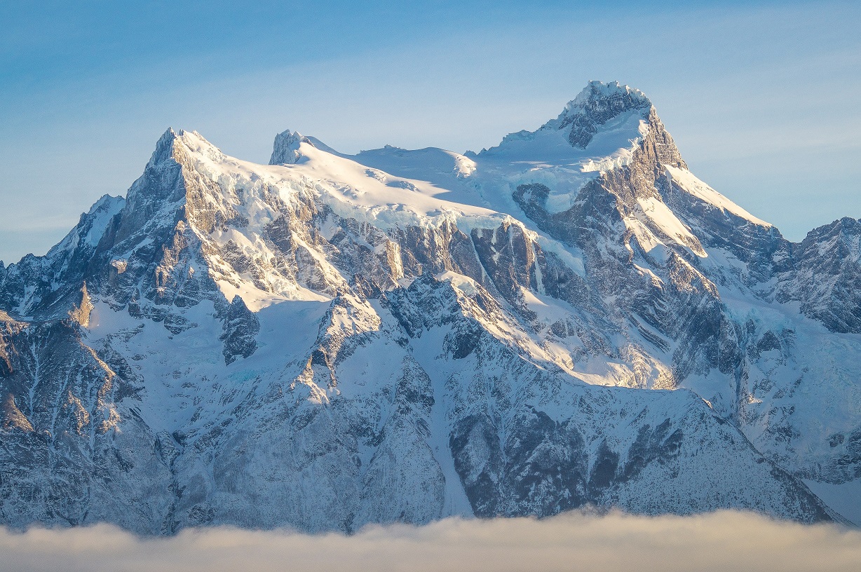 Massive snowy peaks of Cerro Paine Grande under a light mist in the Chilean Patagonia.