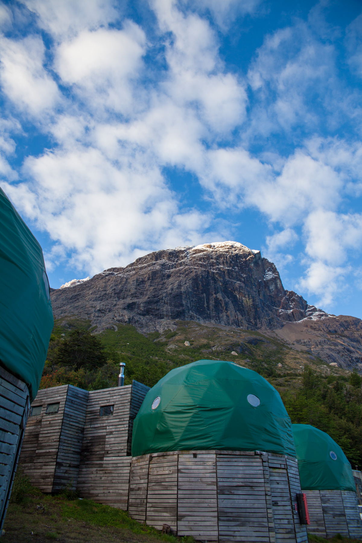 Distinctive white trekking domes at Domo Francés surrounded by lush Patagonian forest.