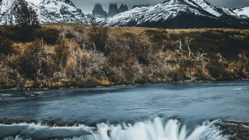 Una vista panorámica de la profunda Laguna Azul, rodeada de pampa dorada y colinas escarpadas.