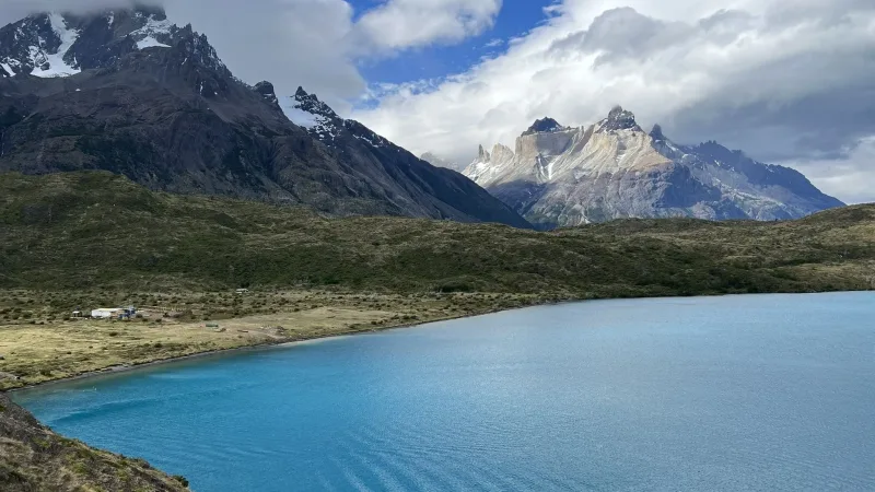 Crystal clear turquoise waters of Lake Pehoé reflecting the majestic mountain peaks on a calm day.