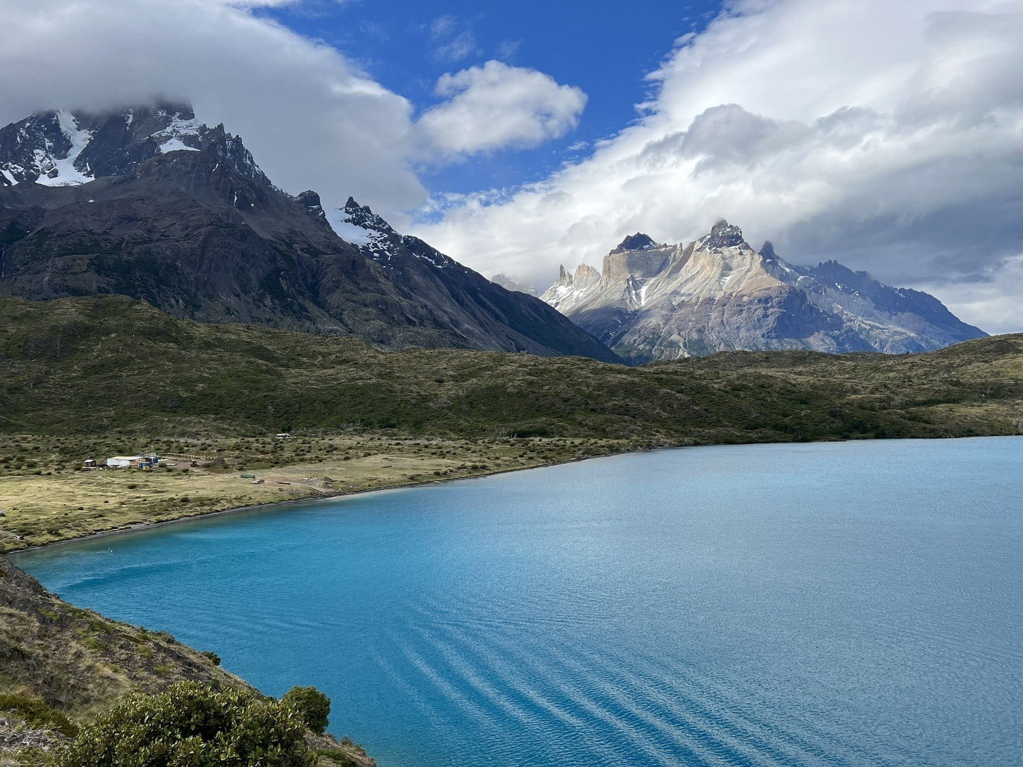Las aguas cristalinas de color turquesa del lago Pehoé reflejan las majestuosas cumbres de las montañas en un día tranquilo.