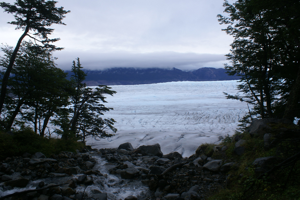 Mochileiros percorrendo a descida íngreme e nevada de Paso John Gardner, com vistas para o Campo de Gelo Sul.