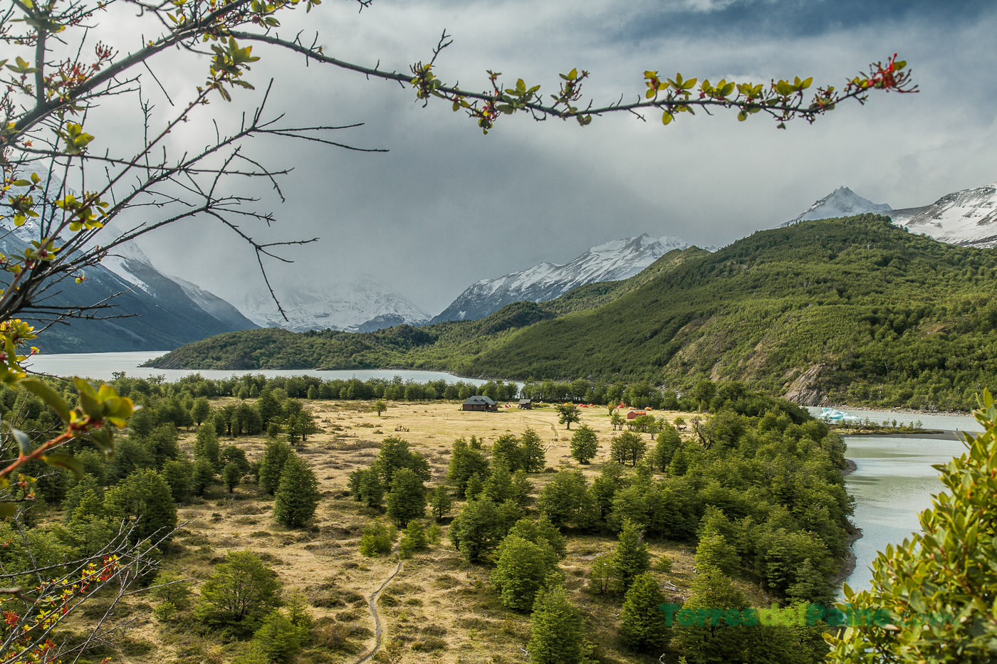 The wooden main building of Refugio Dickson nestled in a green valley near the glacier.