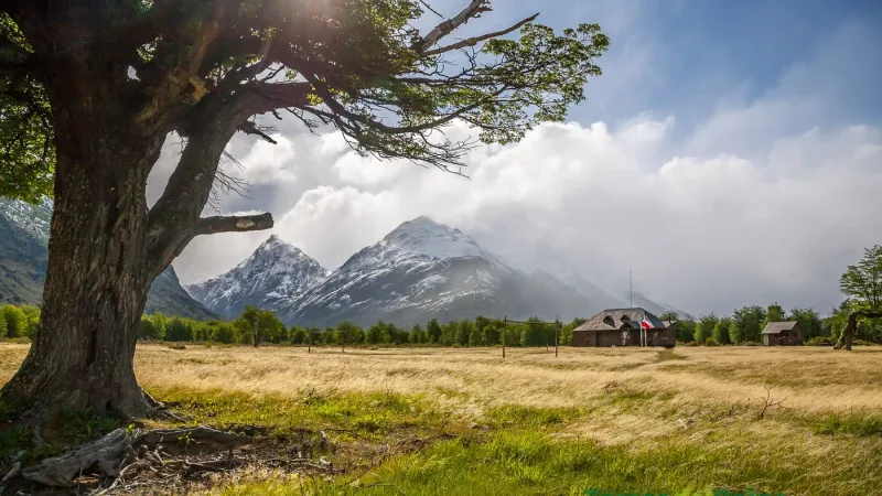 A serene landscape of the lake and mountains as seen from the shore near Camping Dickson.
