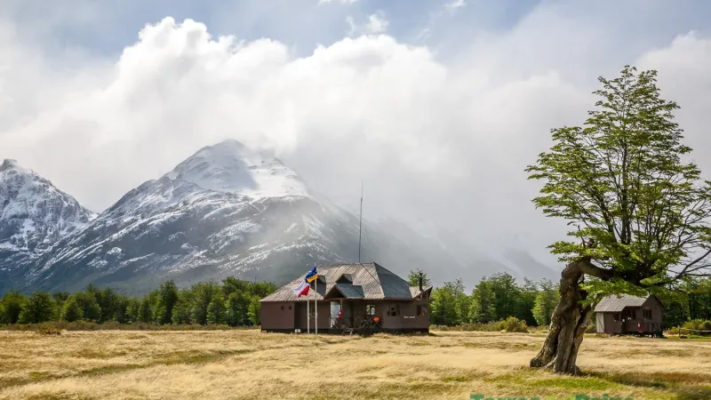Low-angle view of the Refugio Dickson building with the granite towers visible in the far distance.