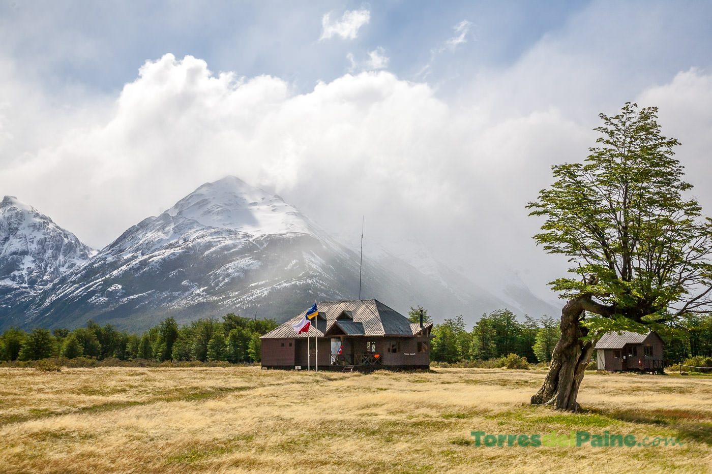 Low-angle view of the Refugio Dickson building with the granite towers visible in the far distance.
