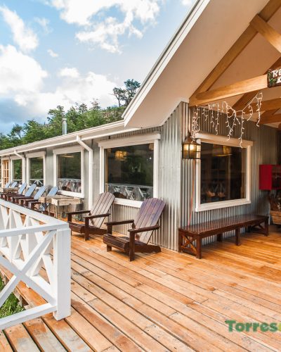 The warm and welcoming common area at Refugio Grey with wooden tables and local decor.