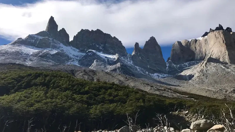 Formações rochosas irregulares e picos nevados com vista para a trilha pelo Vale Francês.