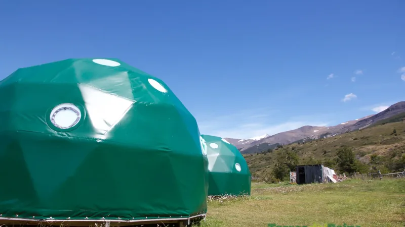 Early morning sun lighting up the green fields and wildflowers at Camping Serón.