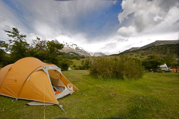 Hikers walking through the lush vegetation on the trail leading away from Camping Serón.