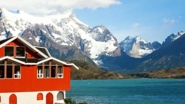 Uma aconchegante área de estar dentro da Hosteria Pehoé, com grandes janelas com vista para o lago e as montanhas.