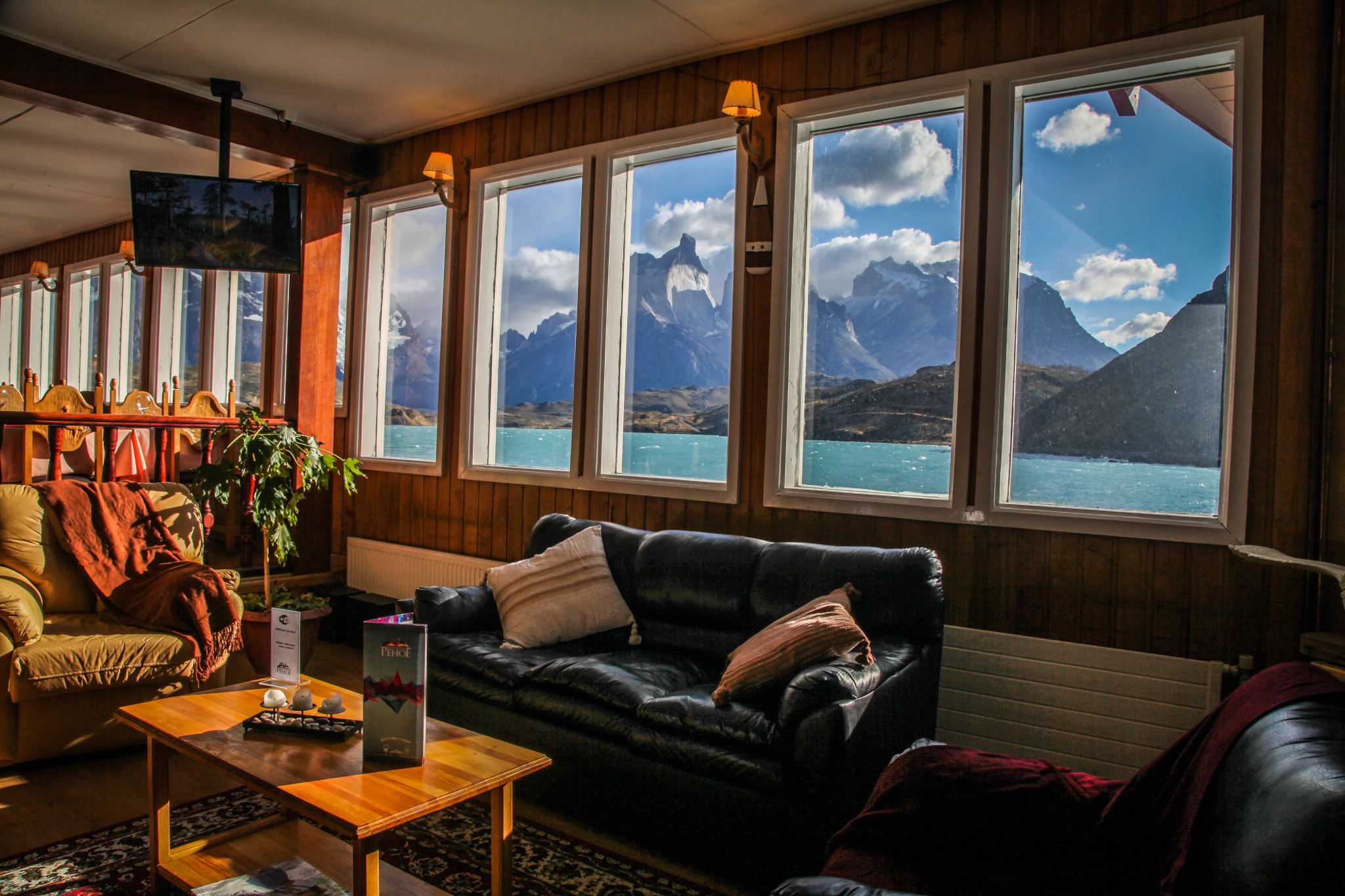 Cómoda habitación en la Hosteria Pehoé con decoración rústica y vistas a la montaña.