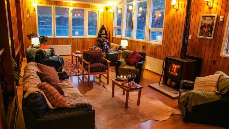 Pasillo interior de la Hosteria Pehoé con cálidos paneles de madera y obras de arte locales.