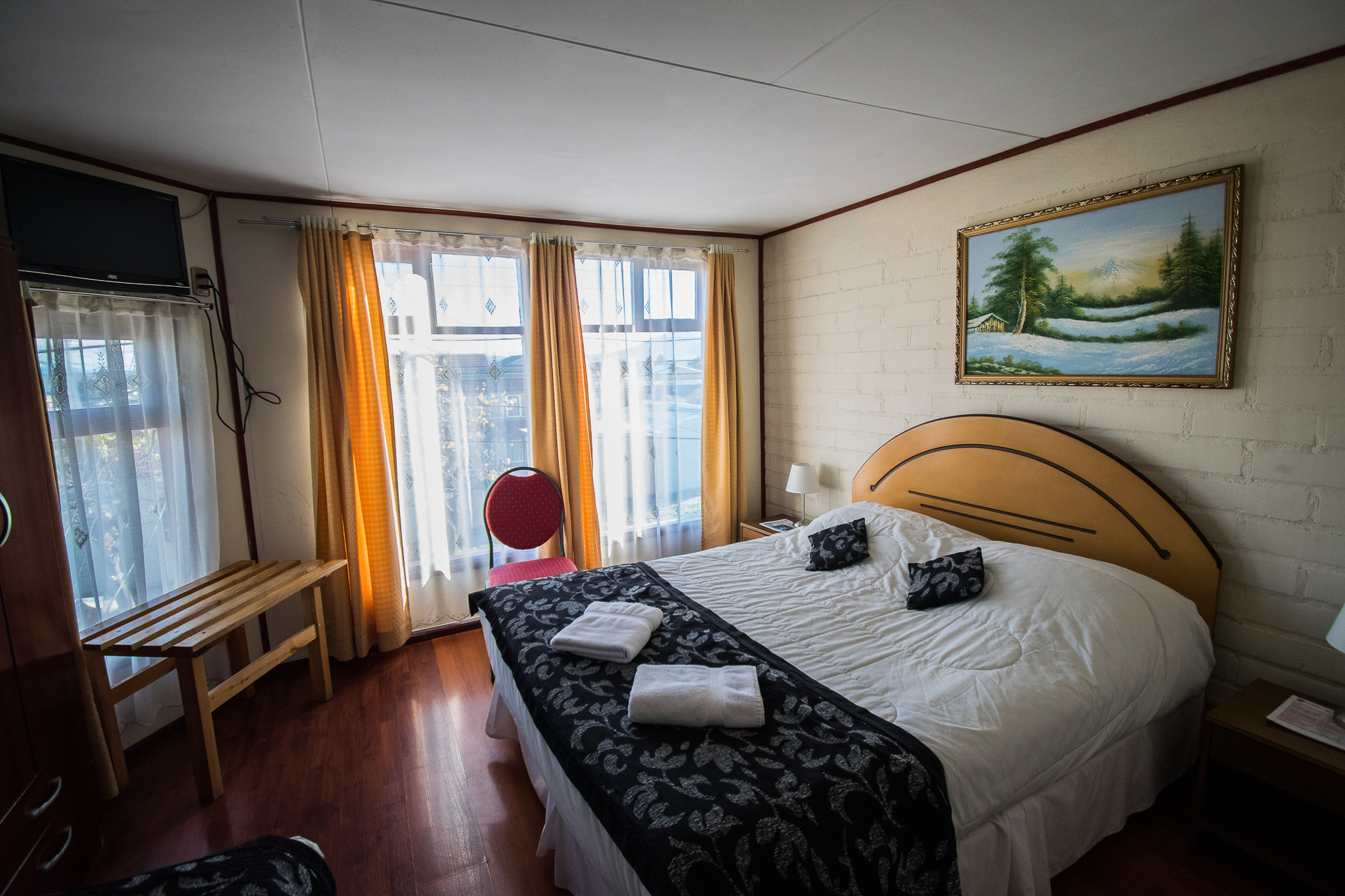 A comfortable double room featuring neutral tones and a large wardrobe.