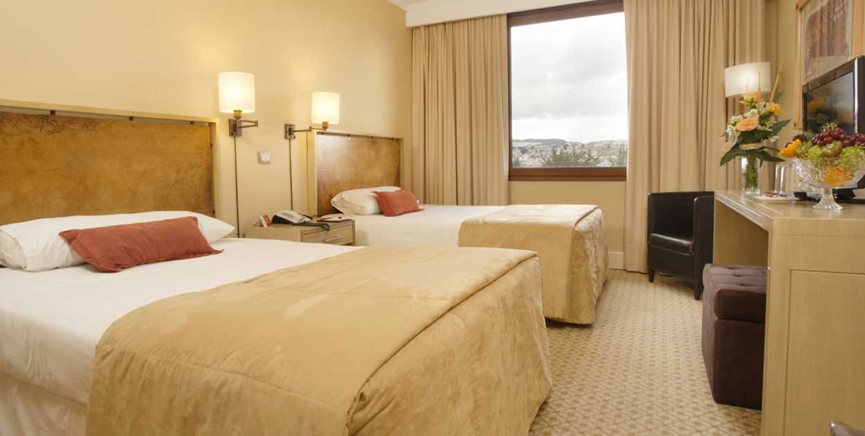 Acogedor y refinado salón en el Hotel Cabo de Hornos, con mobiliario clásico e iluminación cálida.