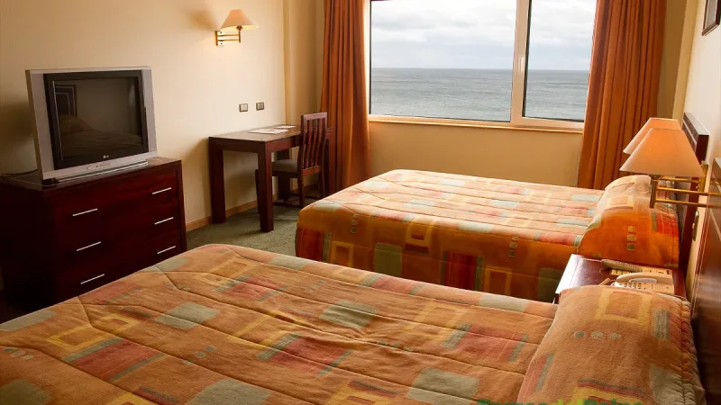 Um quarto standard no Hotel Diego de Almagro com decoração clássica e duas camas de casal.