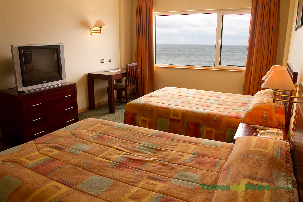 Um quarto standard no Hotel Diego de Almagro com decoração clássica e duas camas de casal.