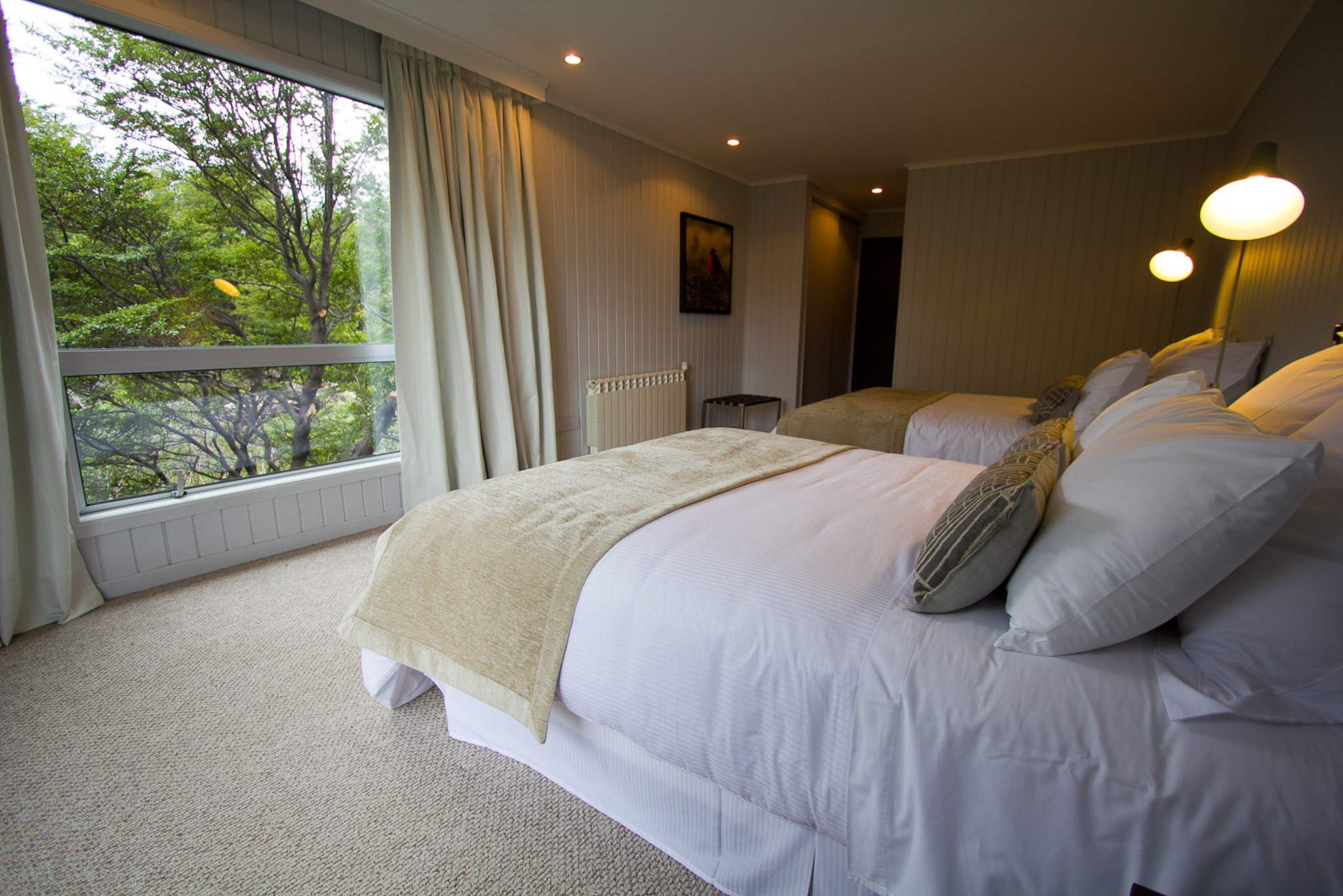 A cozy superior room at Hotel Lago Grey with large windows looking out towards the glacier.