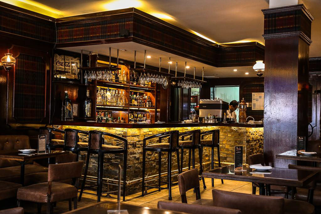 Una acogedora habitación doble en el Hotel Los Navegantes con muebles de madera tradicionales y ropa de cama de lujo.