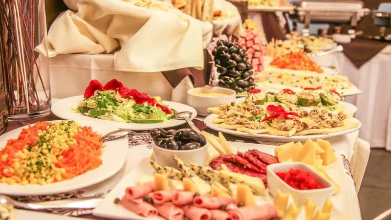 O amplo salão de jantar e a área do restaurante do Hotel Los Navegantes, preparados para uma refeição formal.