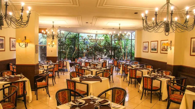 Uma suíte bem equipada no Hotel Los Navegantes, oferecendo uma área de estar confortável e vista para a cidade.