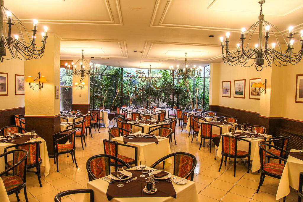Una suite bien equipada en el Hotel Los Navegantes que ofrece una cómoda sala de estar y vistas a la ciudad.