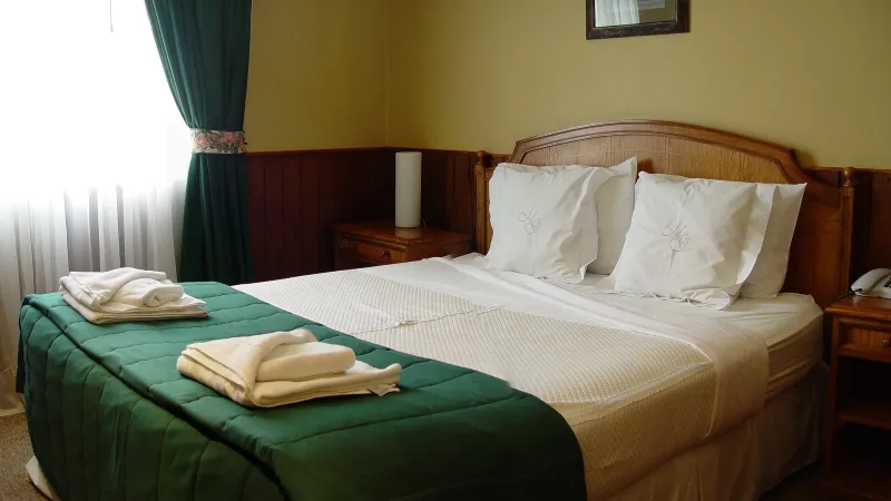 Um quarto superior no Hotel Martin Gusinde com uma pequena área de estar e acabamentos elegantes.