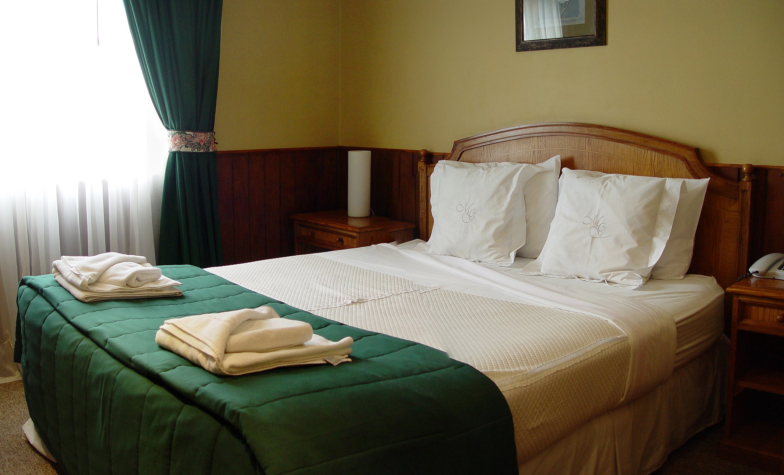 A superior room at Hotel Martin Gusinde featuring a small sitting area and elegant finishes.