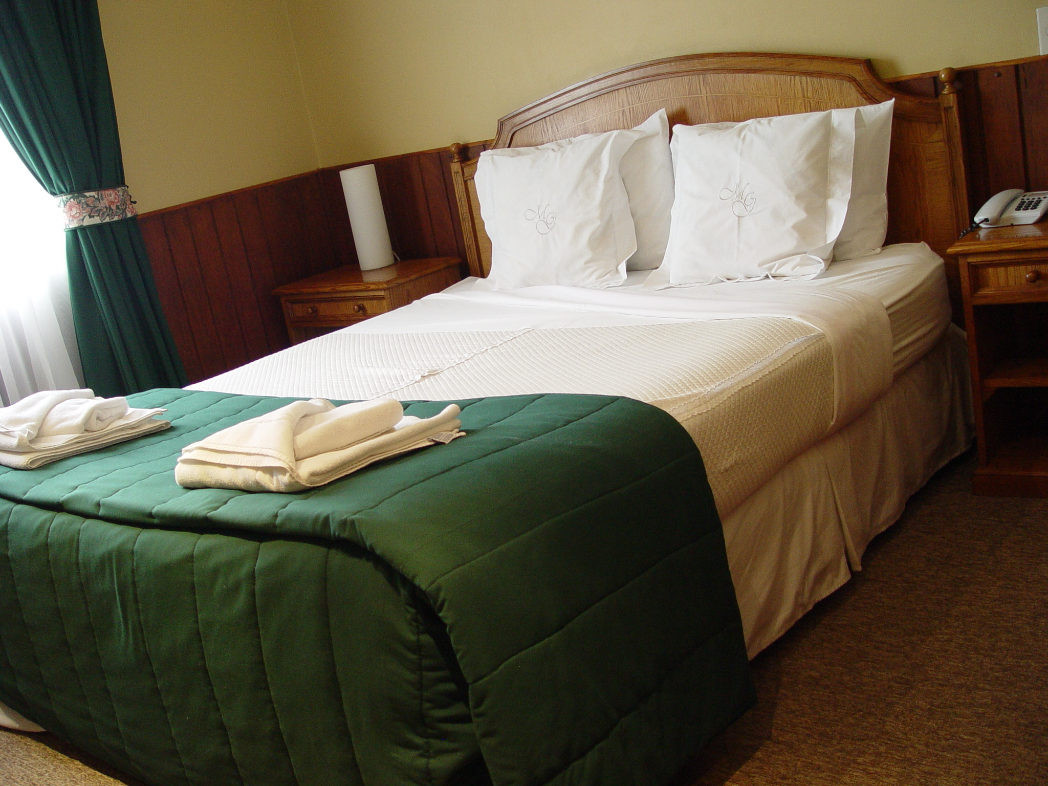 A standard double room at Hotel Martin Gusinde with clean linens and warm interior lighting.