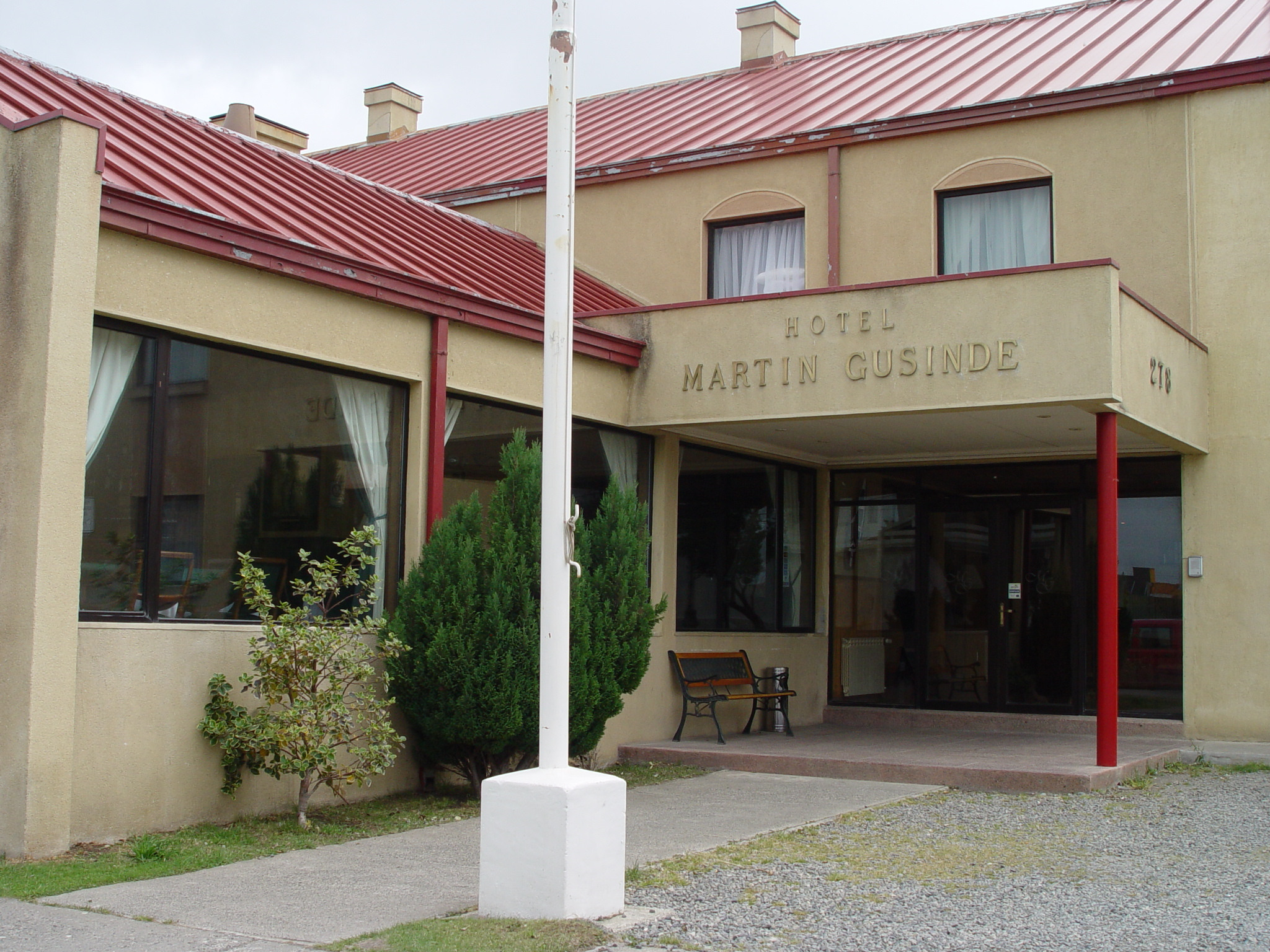 Twin beds in a guest room at Hotel Martin Gusinde, showing a simple and comfortable setup.