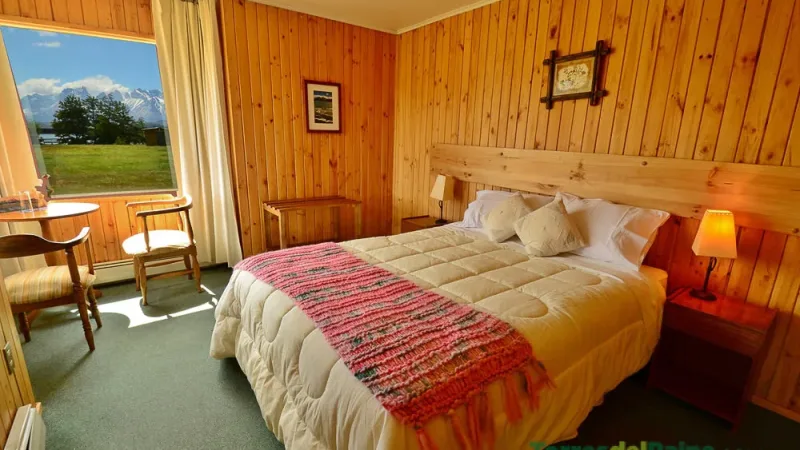 The cozy common area of Hotel Paine with large windows overlooking the surrounding mountains.