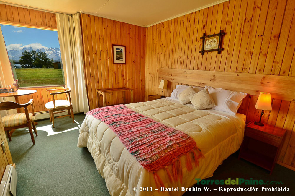 The cozy common area of Hotel Paine with large windows overlooking the surrounding mountains.
