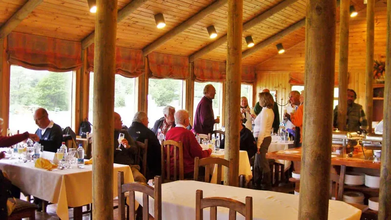 A comfortable guest room at Hotel Paine with rustic wooden decor and views of the Patagonian landscape.