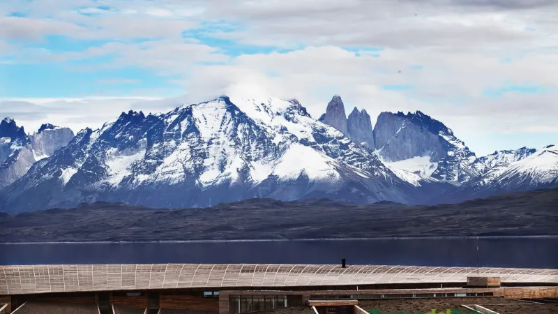 Una piscina cubierta en el Uma Spa de Tierra Patagonia, con vistas a las montañas a través de enormes paredes de cristal.