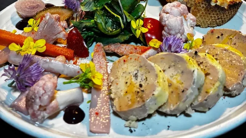 Prato elaborado com frios, flores comestíveis e pães torrados no restaurante La Cuisine, em Punta Arenas
