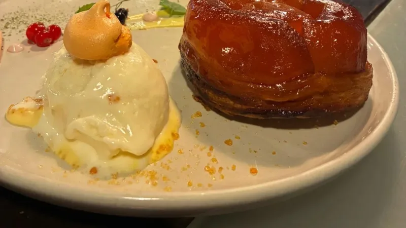 Sobremesa com massa folhada caramelizada e sorvete em prato branco no restaurante La Cuisine, Punta Arenas