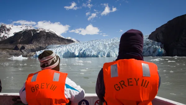 Primer plano de los pasajeros en la cubierta del barco Grey III, admirando las imponentes paredes del glaciar Grey.