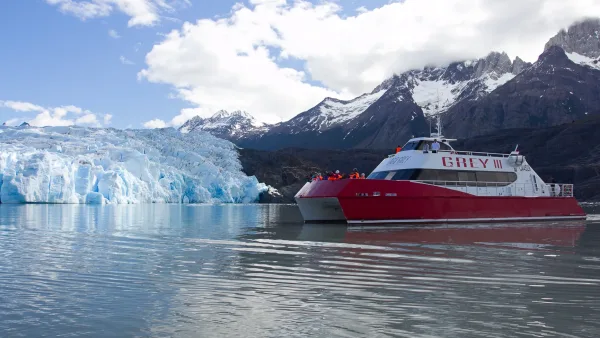 The catamaran approaching the face of Glacier Grey, showing the immense scale of the ice cliffs.