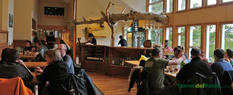 Cozy common area inside Refugio Torre Central with hikers resting and preparing their packs.