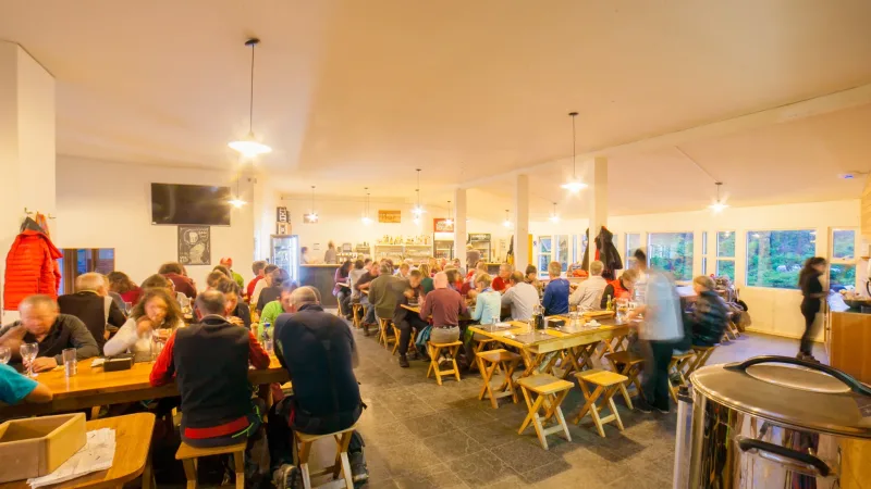 Bright and airy interior of the Refugio Torres Central lobby with high wooden ceilings.