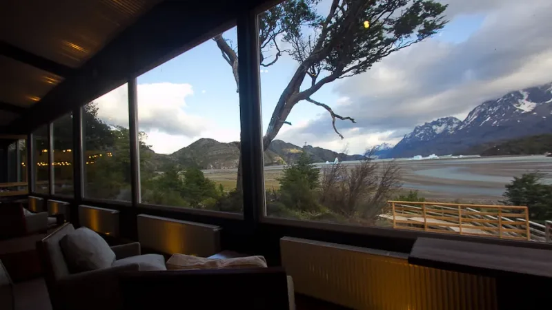 Garçons servindo os hóspedes no salão de jantar amplo e iluminado do Hotel Lago Grey.