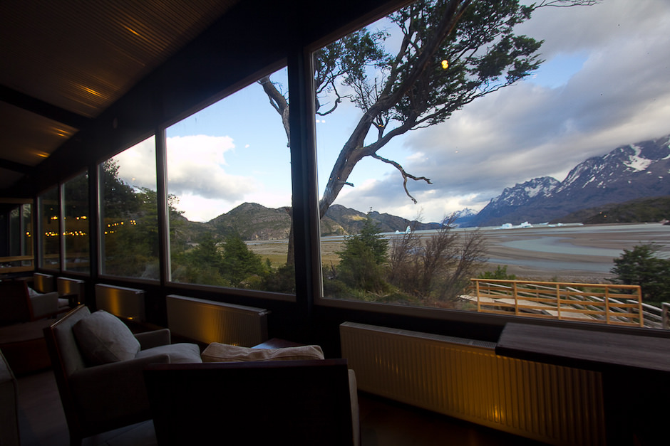 Garçons servindo os hóspedes no salão de jantar amplo e iluminado do Hotel Lago Grey.