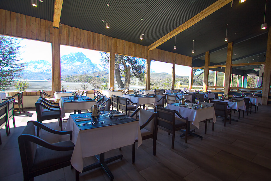 O interior aconchegante de madeira do restaurante à noite, iluminado por uma luz ambiente suave.