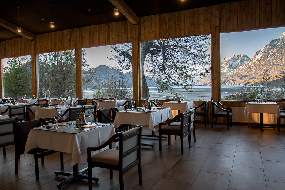 Os clientes brindam com taças de vinho enquanto apreciam o pôr do sol sobre a geleira Grey, a partir do restaurante.